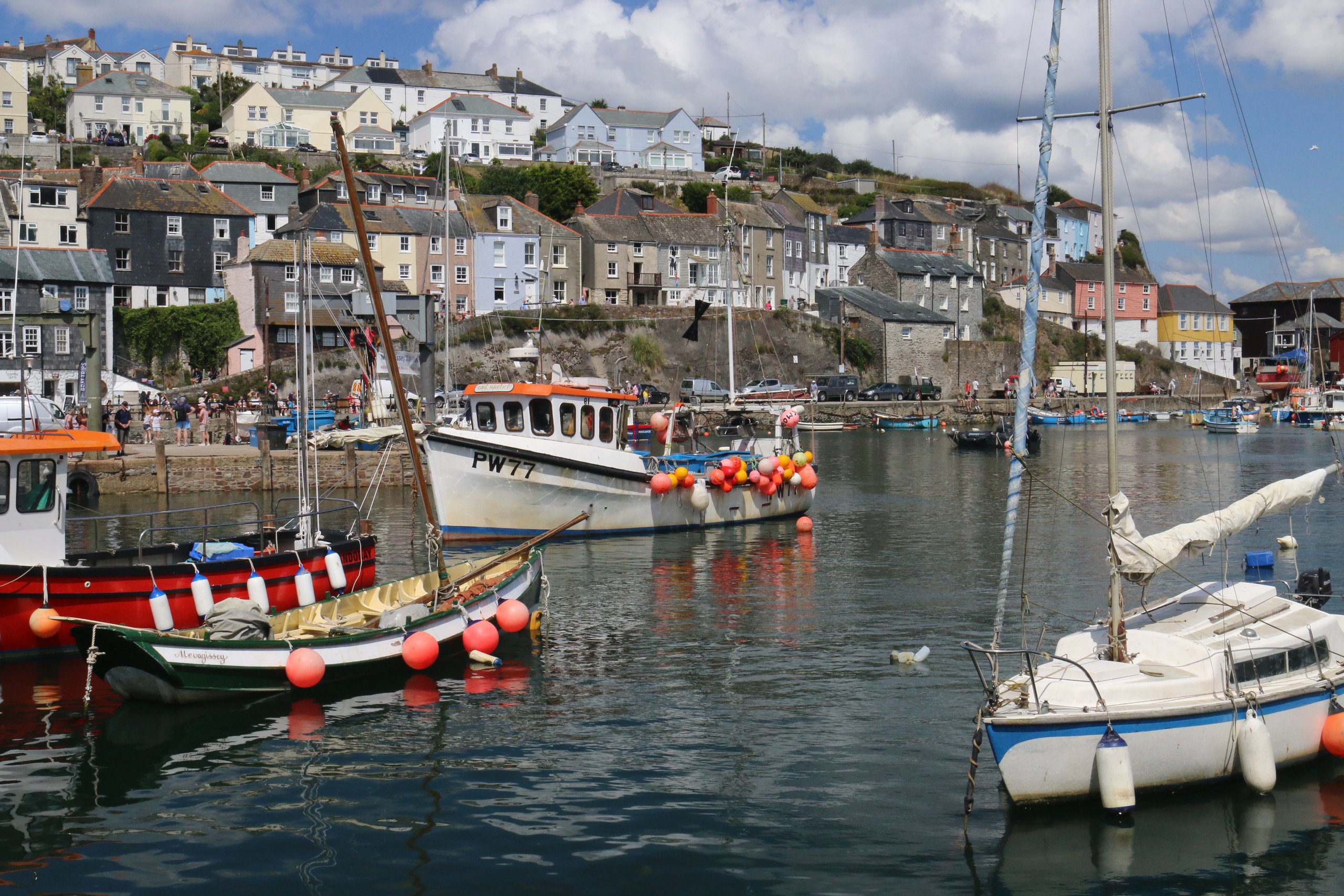 Boats in Mevagissey harbour below the hillside houses