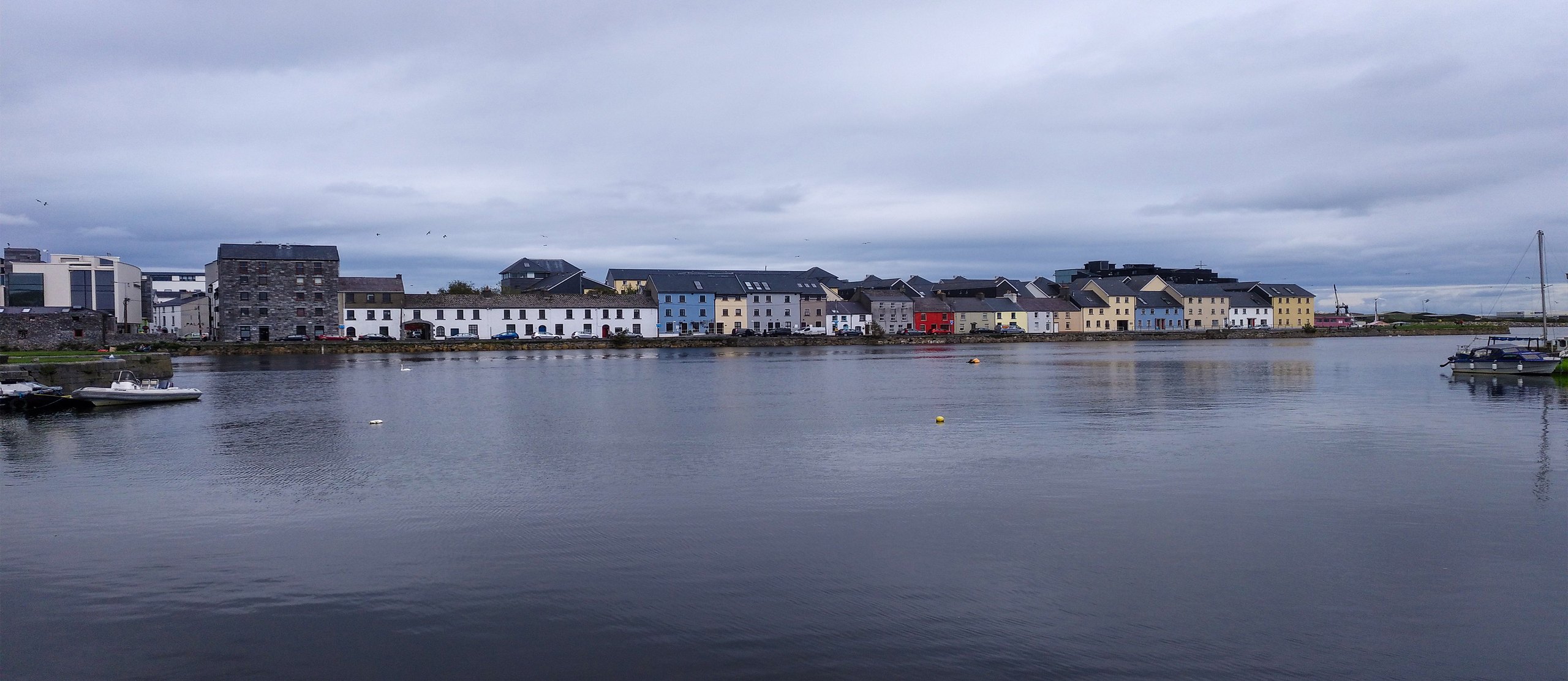 The colourful houses of the Long Walk across the water in Galway