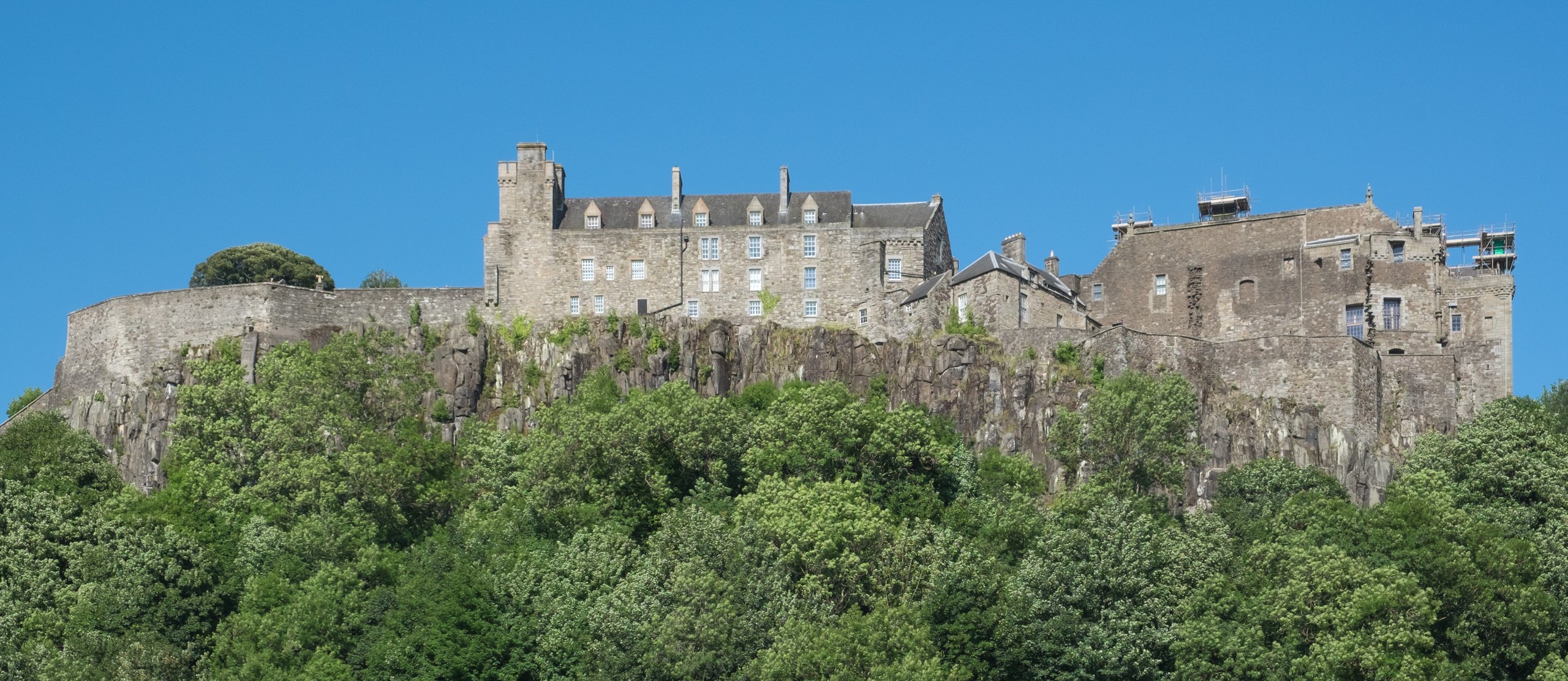 Stirling Castle on its wooded crag under a blue sky